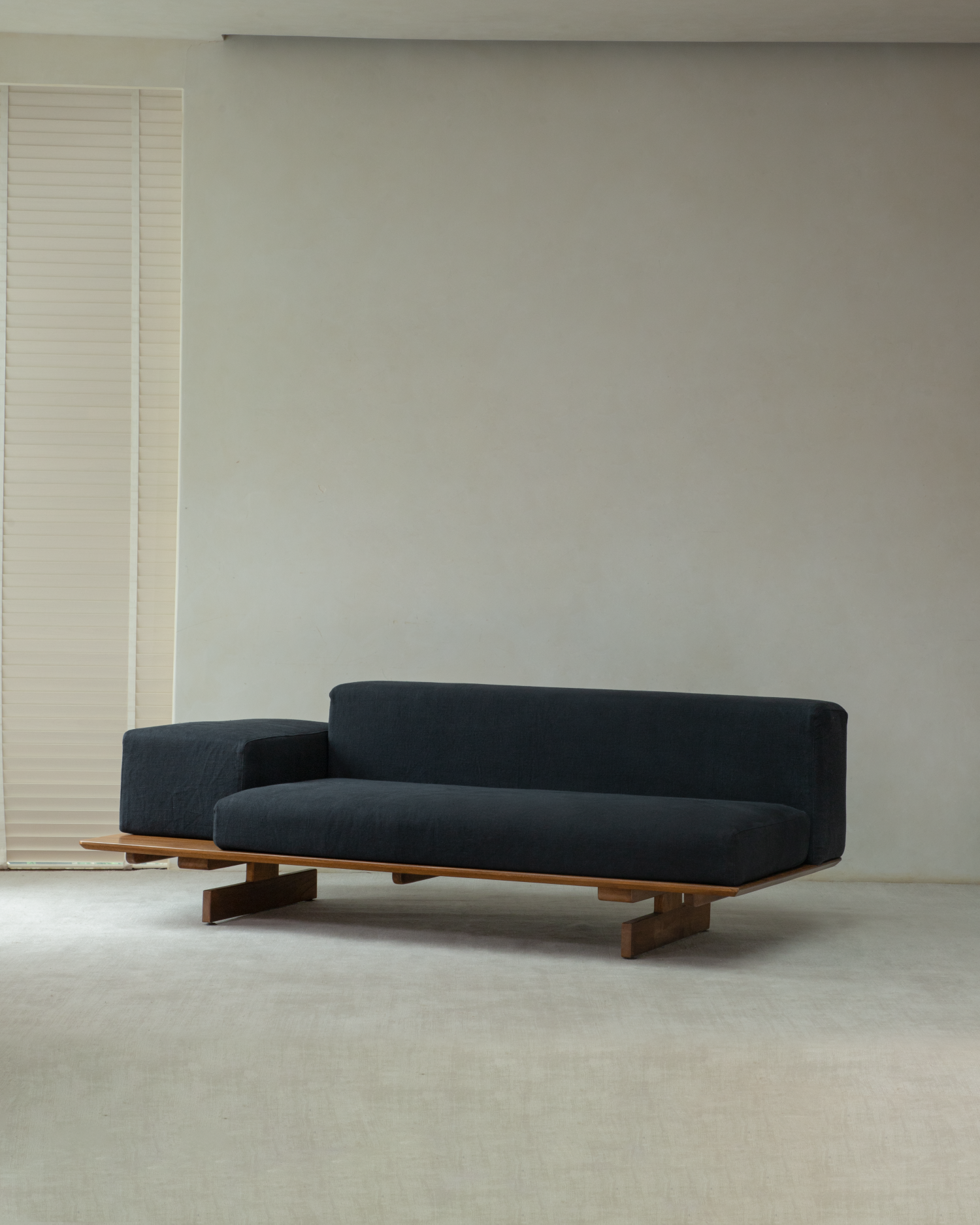 Tatami linen modular sofa in black, featuring a low profile teak wood base and extended side.