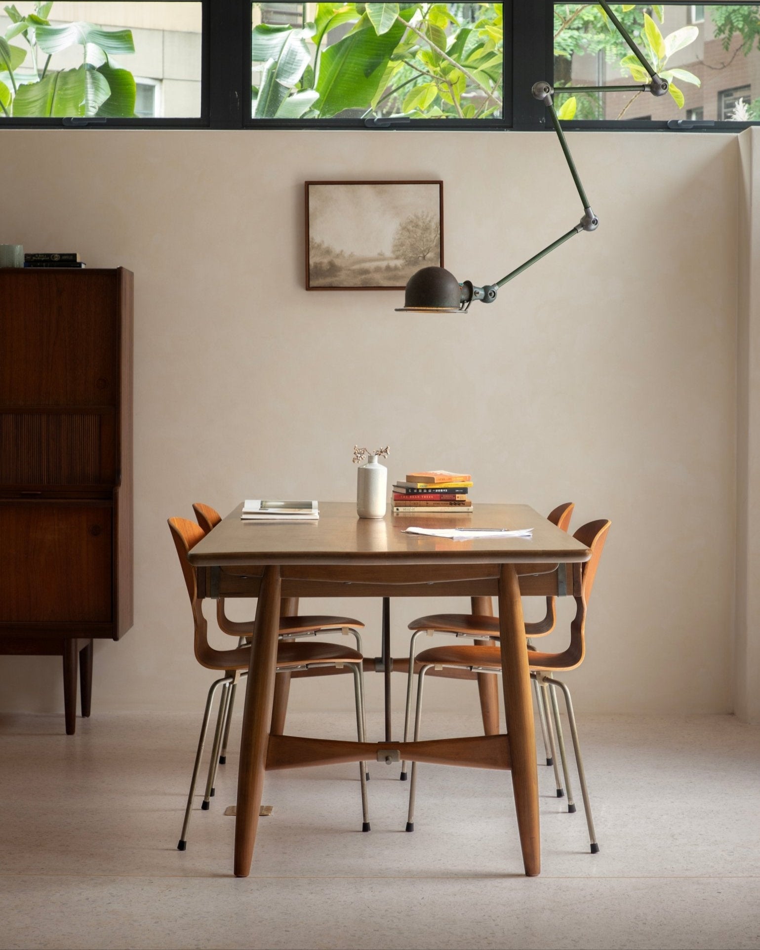Teak wood dining table and chairs in modern workspace, architect desk style.