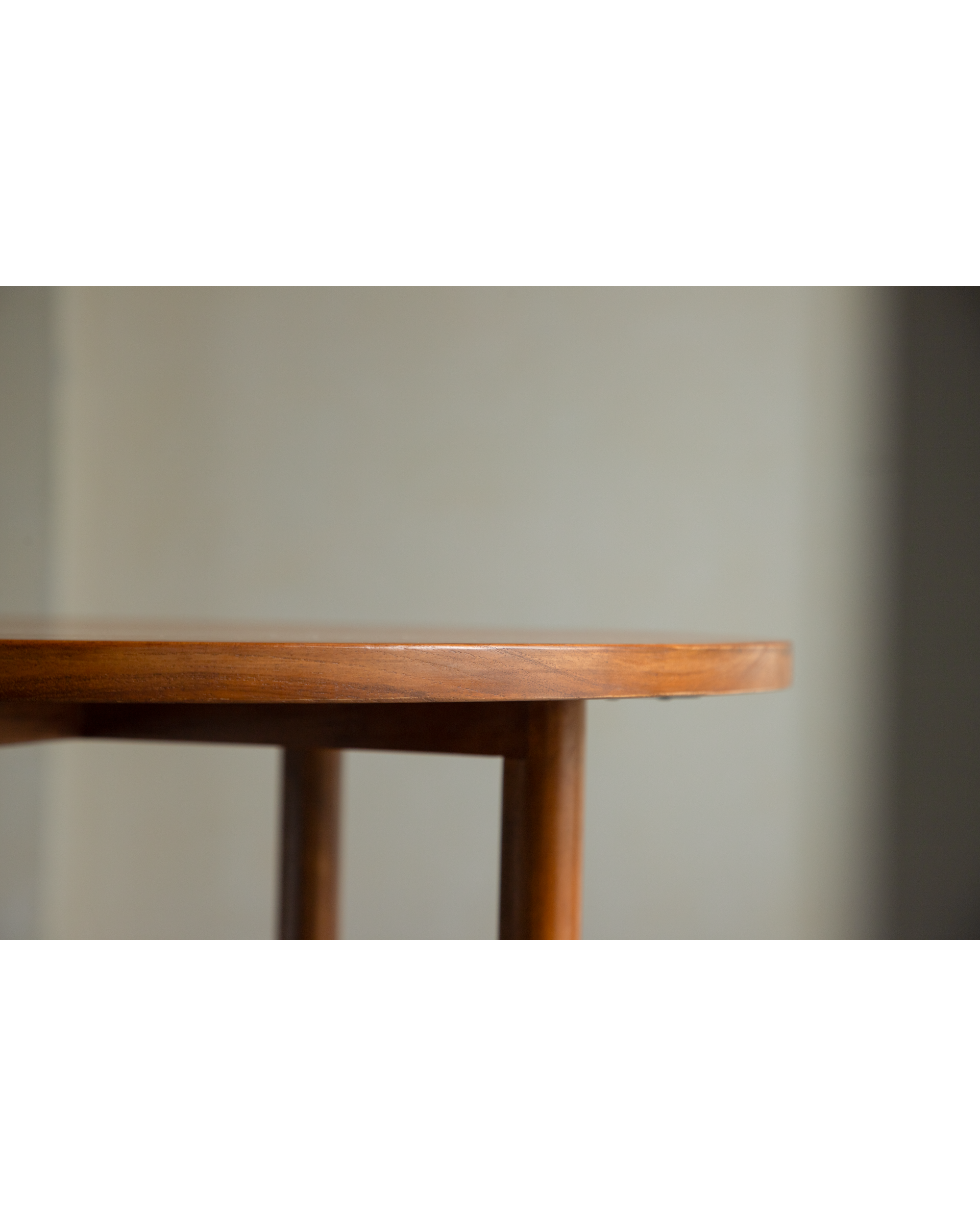 Daisy side table crafted from teak wood, showing curved leg detail.