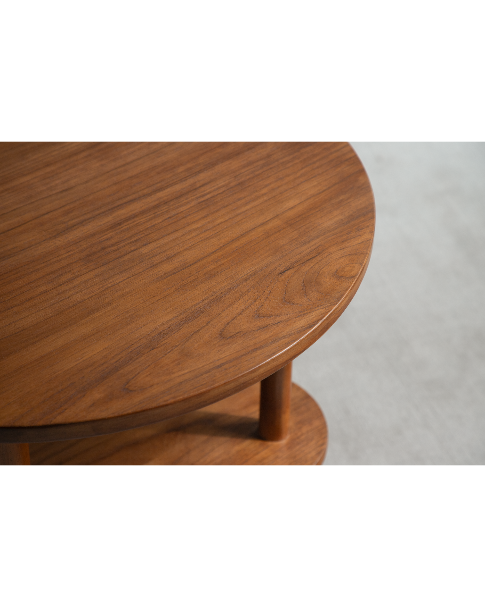 Daisy Side Table: Close-up of round solid teak wood top and curved leg.