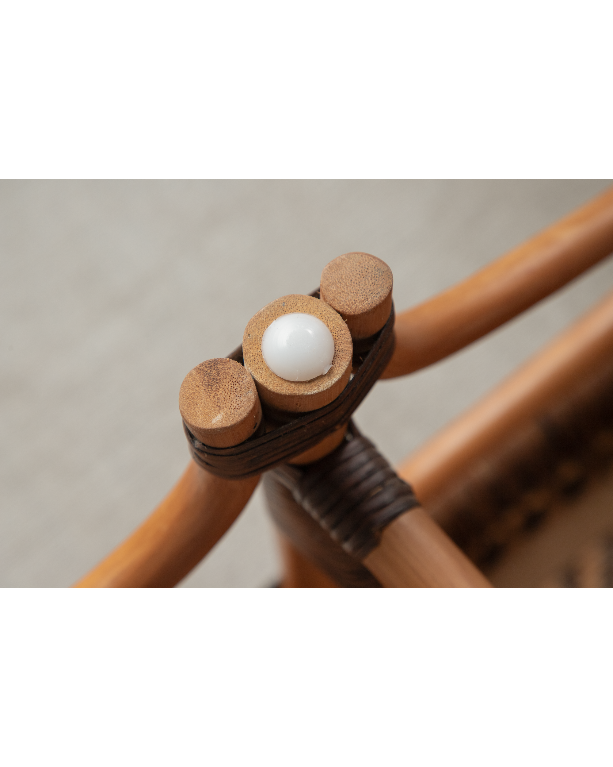 Close-up of Melange Bench bamboo rattan joint with woven binding and rounded connector detail