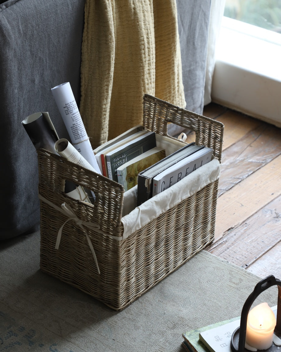 Elara Storage Basket: natural woven rattan with handles, organizing books.