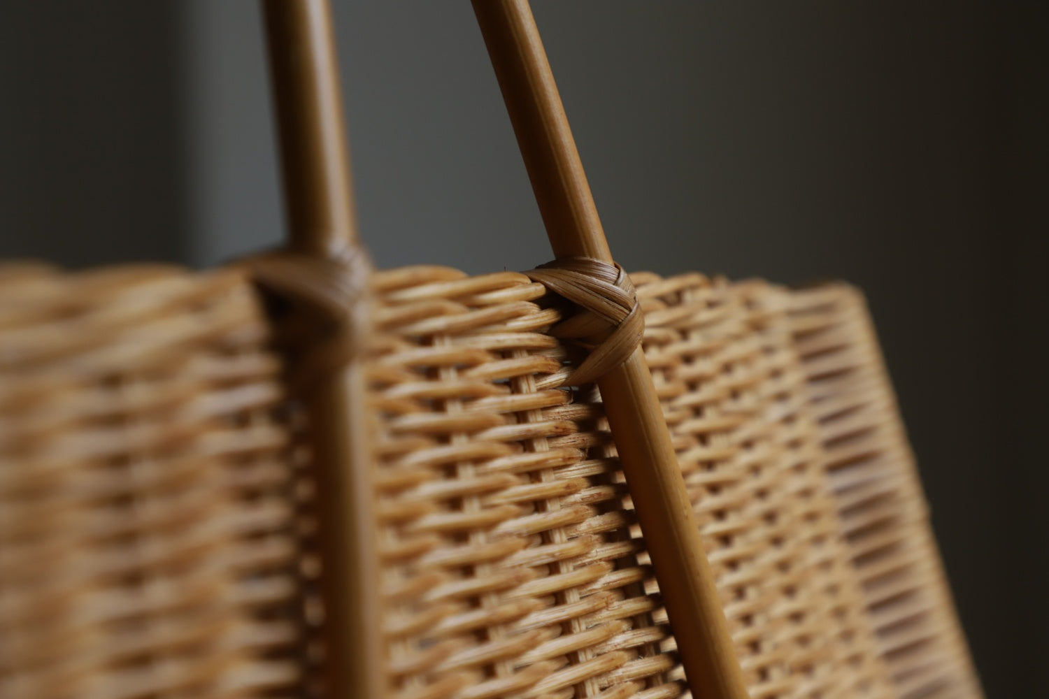 Hand-woven rattan basket detail, showing natural material weave and sturdy handle construction.