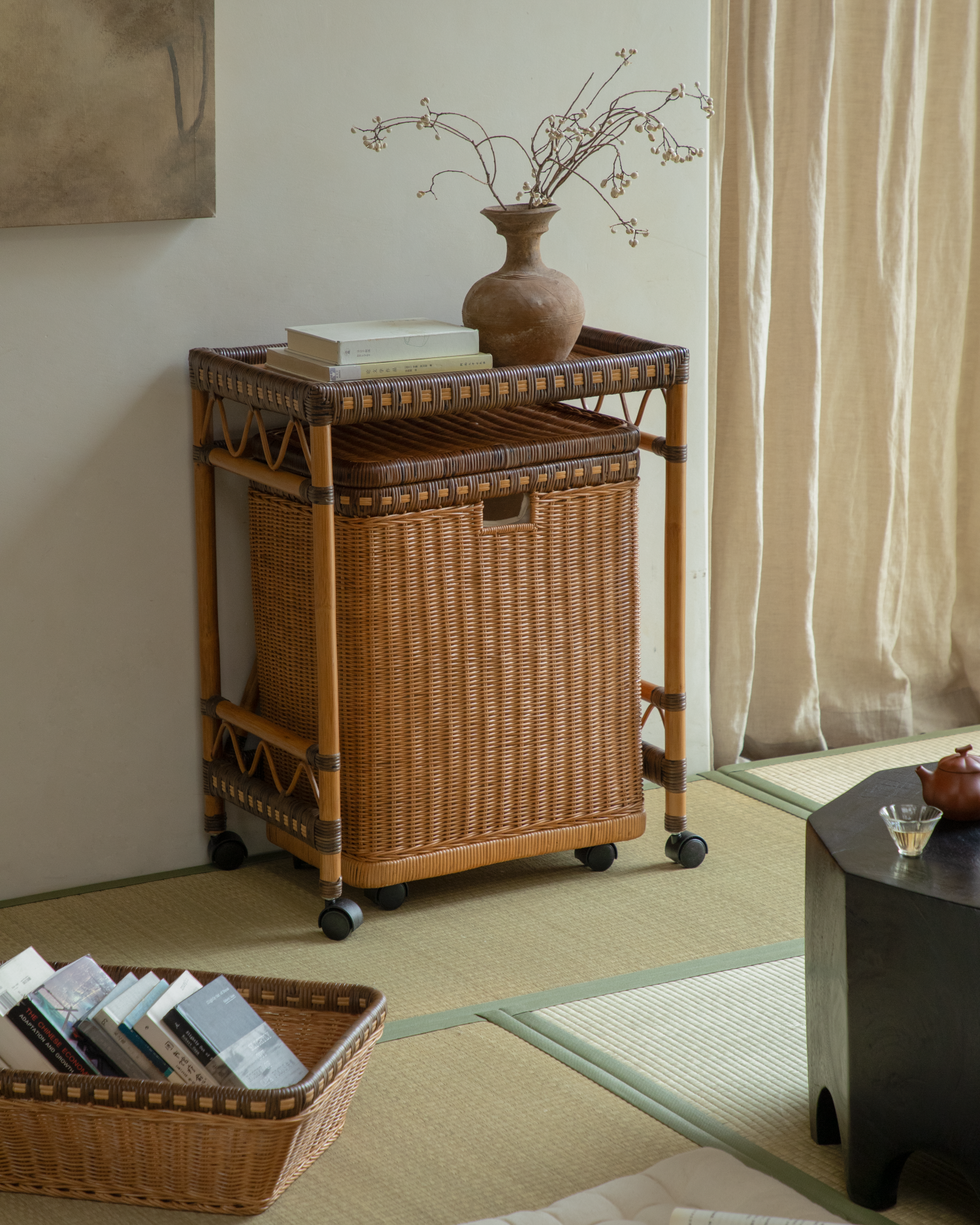 Milo Rattan Laundry Cart: Woven natural rattan with storage basket and wheels.