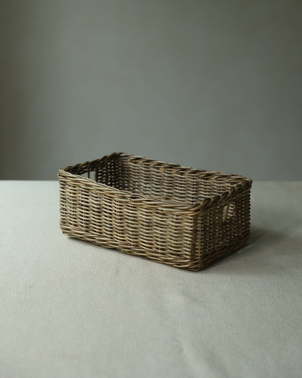 Etta Storage Basket, hand-woven from natural rattan with integrated handles.