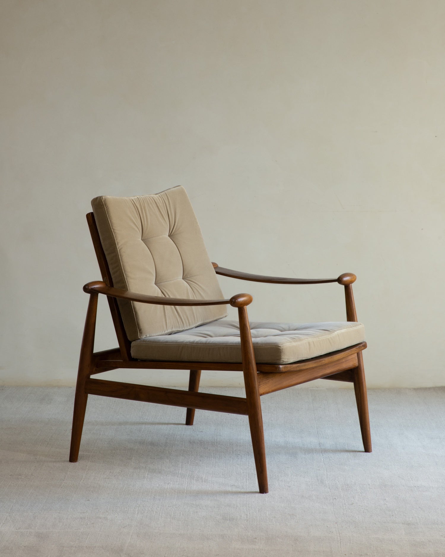 Elise lounge chair: teak frame, spindle legs, sculpted armrests, tufted beige velvet cushion.