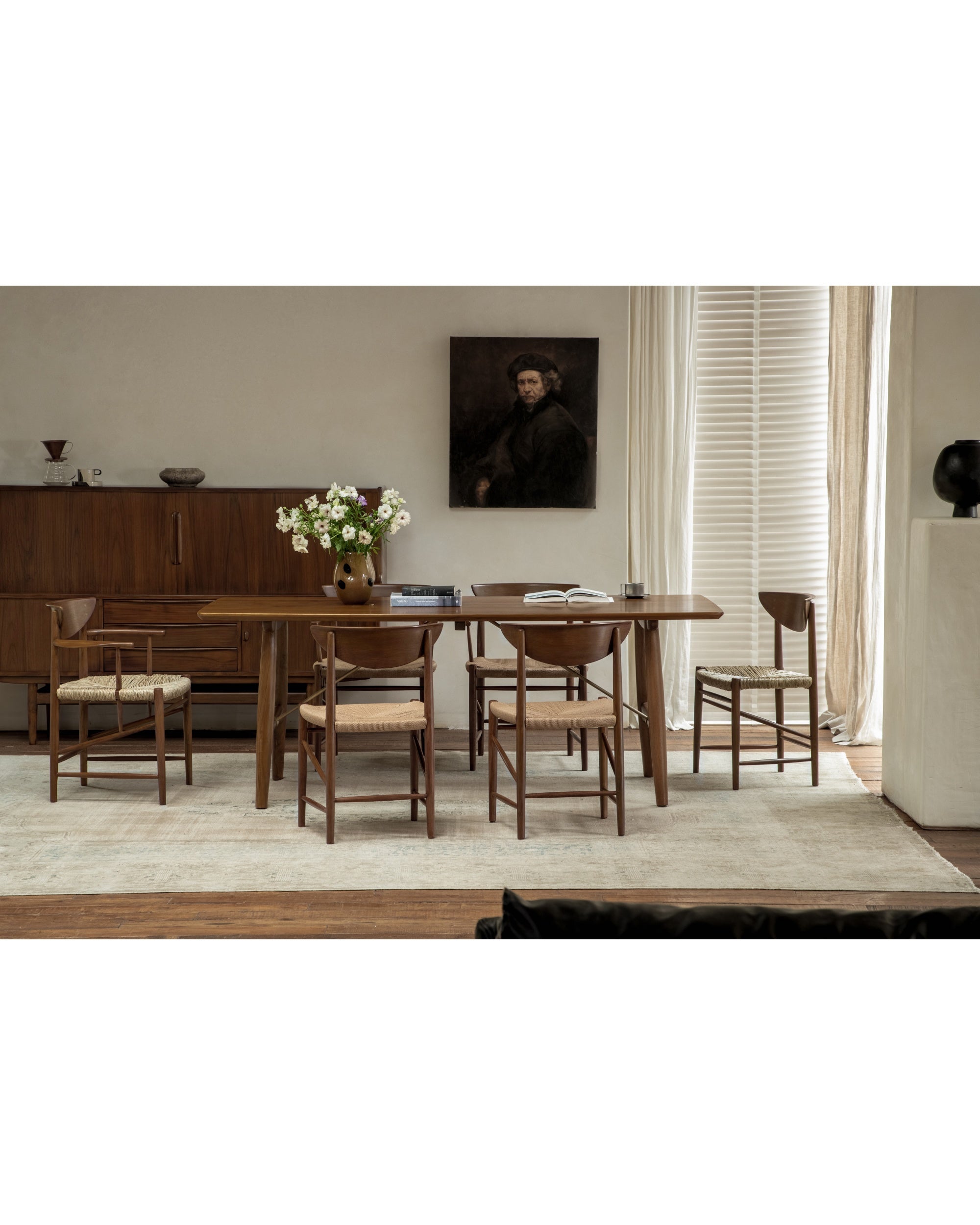 Margaret Dining Chair with teak frame and woven rush seat in a stylish dining room.