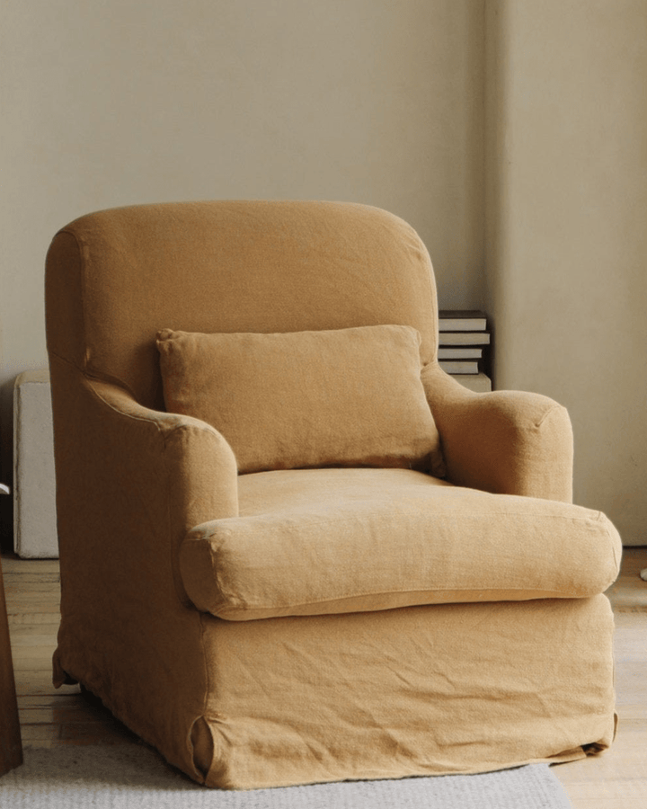 Caramel slipcover armchair with cushion in a bright living space