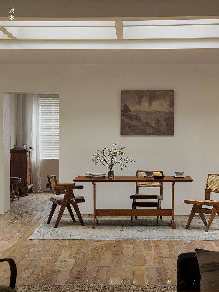 Hoof Dining Table in a cozy dining setting with I-shaped base, solid wood, ZHUOMU brand. Wooden chairs, rug.