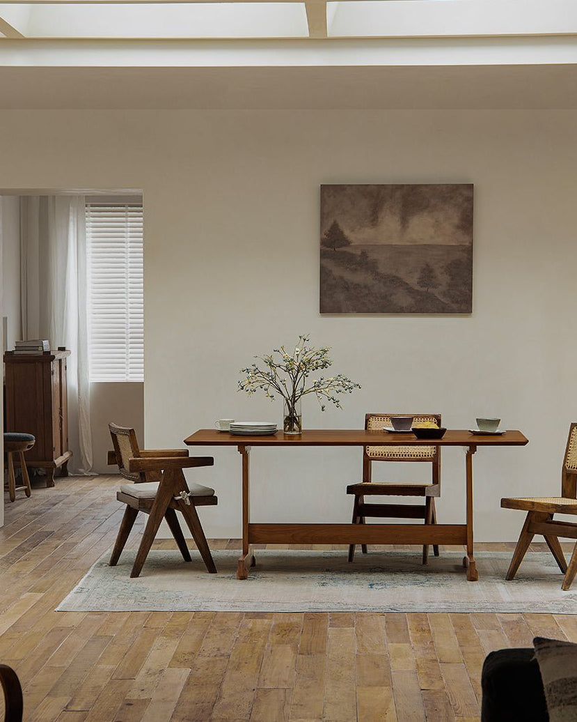 Hoof Dining Table in a cozy dining setting with I-shaped base, solid wood, ZHUOMU brand. Wooden chairs, rug.