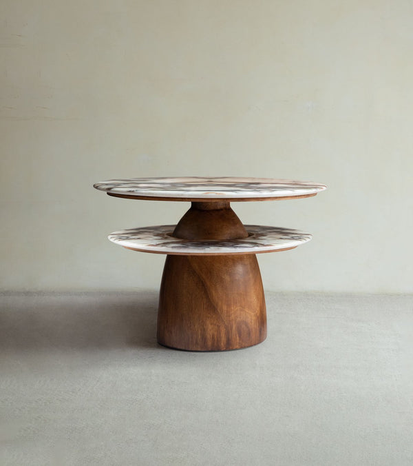 The Dorothy Side Table by ZM Home showcases a round wooden design with marble-like surfaces at varying heights and a solid rain wood base, all set against a plain beige background.