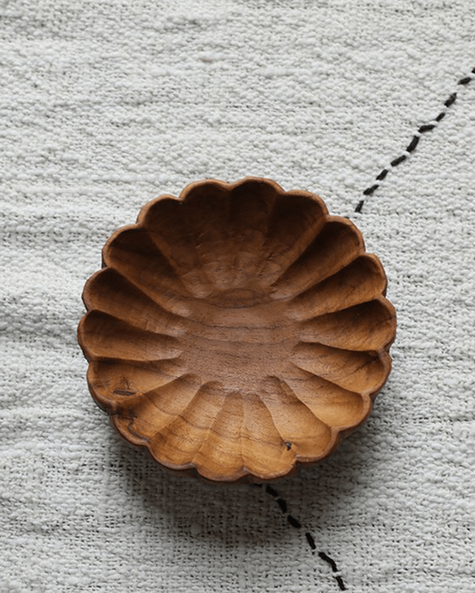 Handmade teak wood lace plate on textured fabric, Indonesian design, elegant dining