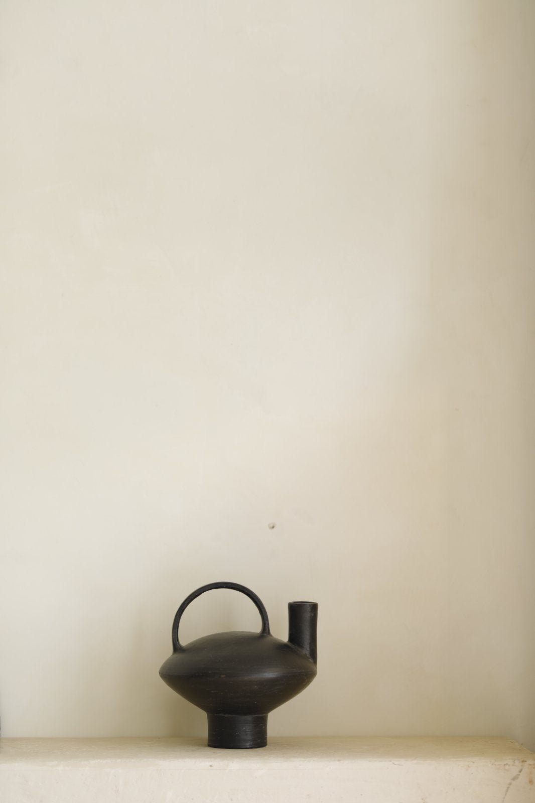 Black ceramic vase with handle and spout, minimalist design, perfect for modern home decor.