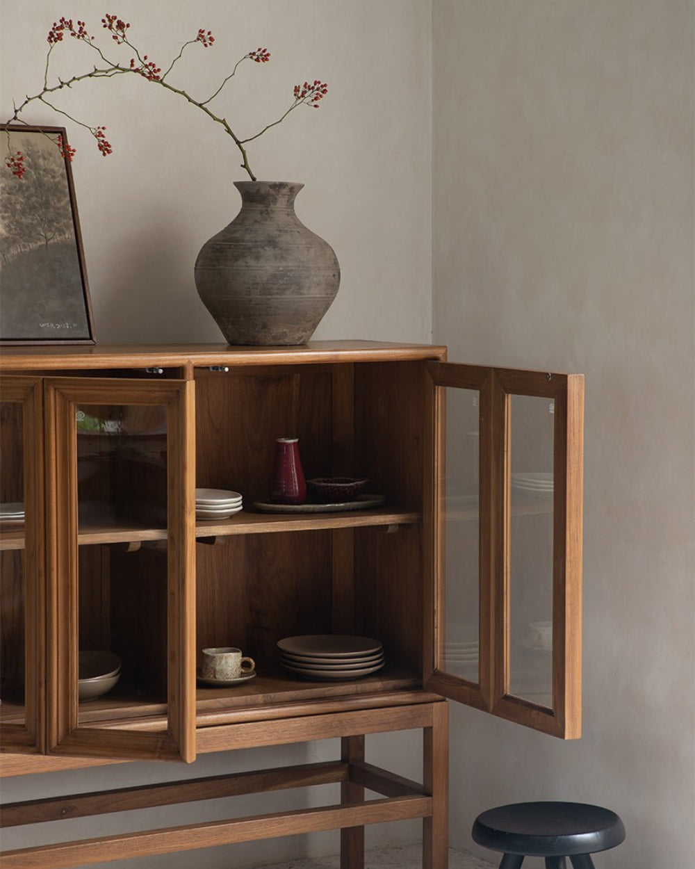 Teak wood Stilt Cabinet with open glass door, showcasing interior storage and decorative items.