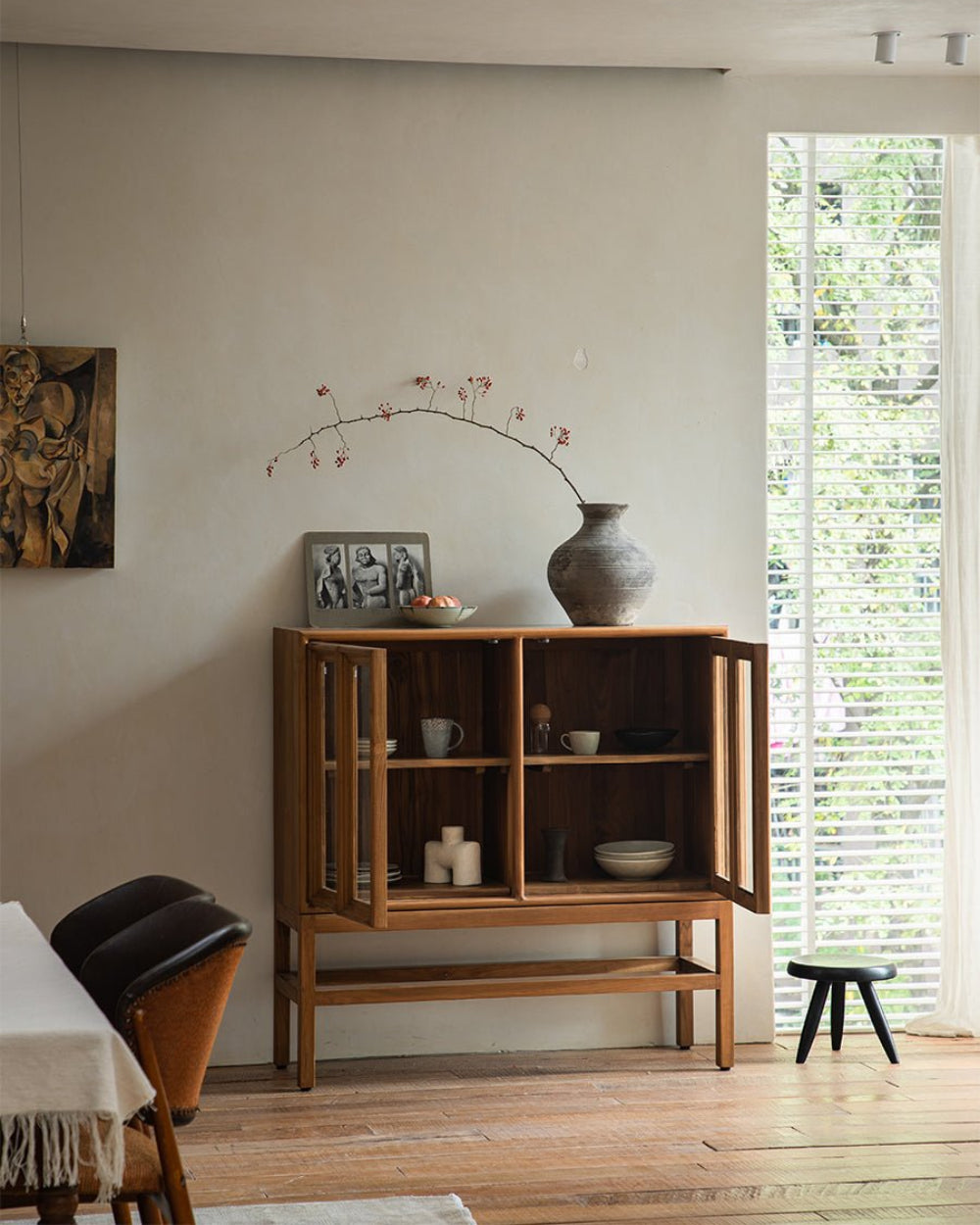 Teak wood stilt cabinet with glass doors showcasing organized interior storage.