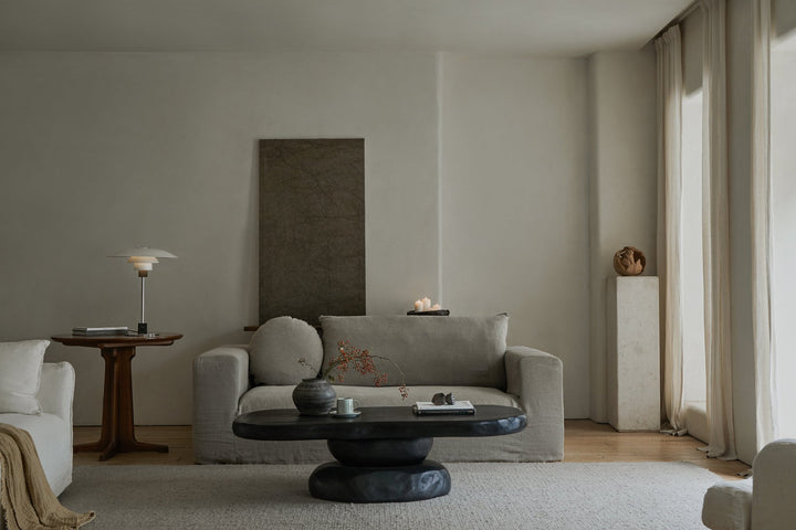 Zen-inspired living room with gray sofa and round black coffee table.