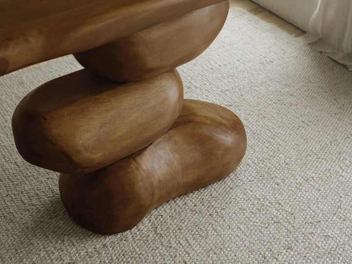Close-up of a sculptural wooden console table with rounded base.