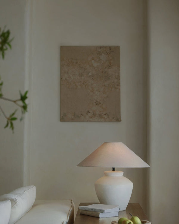 Minimalist living room with white lamp and beige wall art