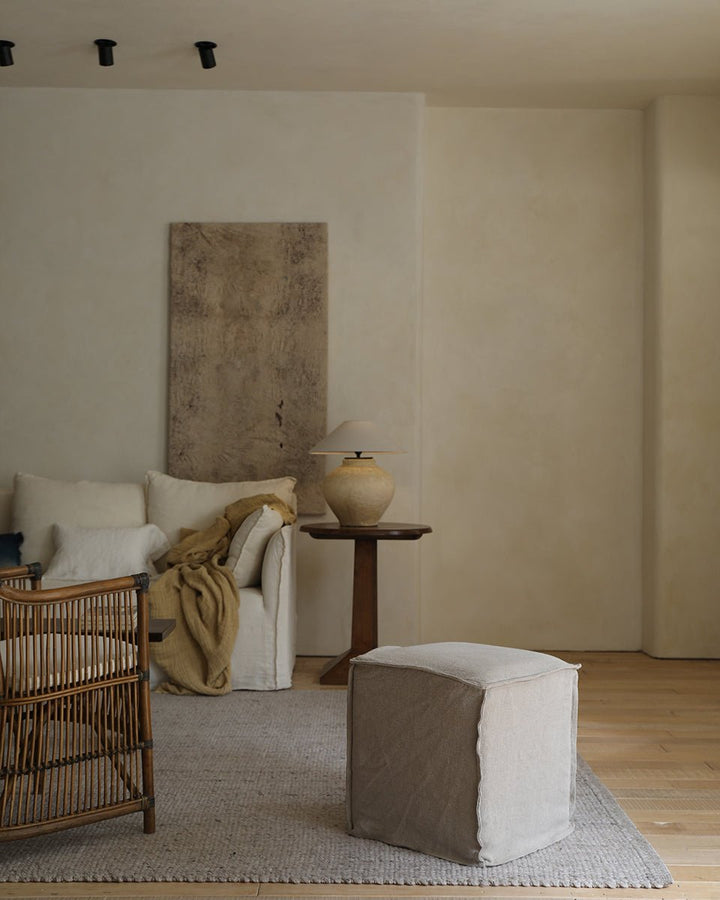Linen cube ottoman in cozy vintage-style living room with soft textures