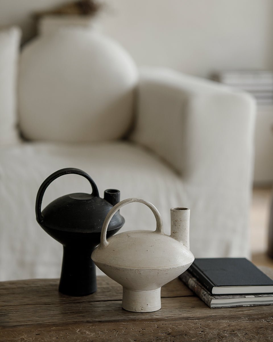 Ceramic vases, black and white with handles, on a wooden table, perfect for home decor