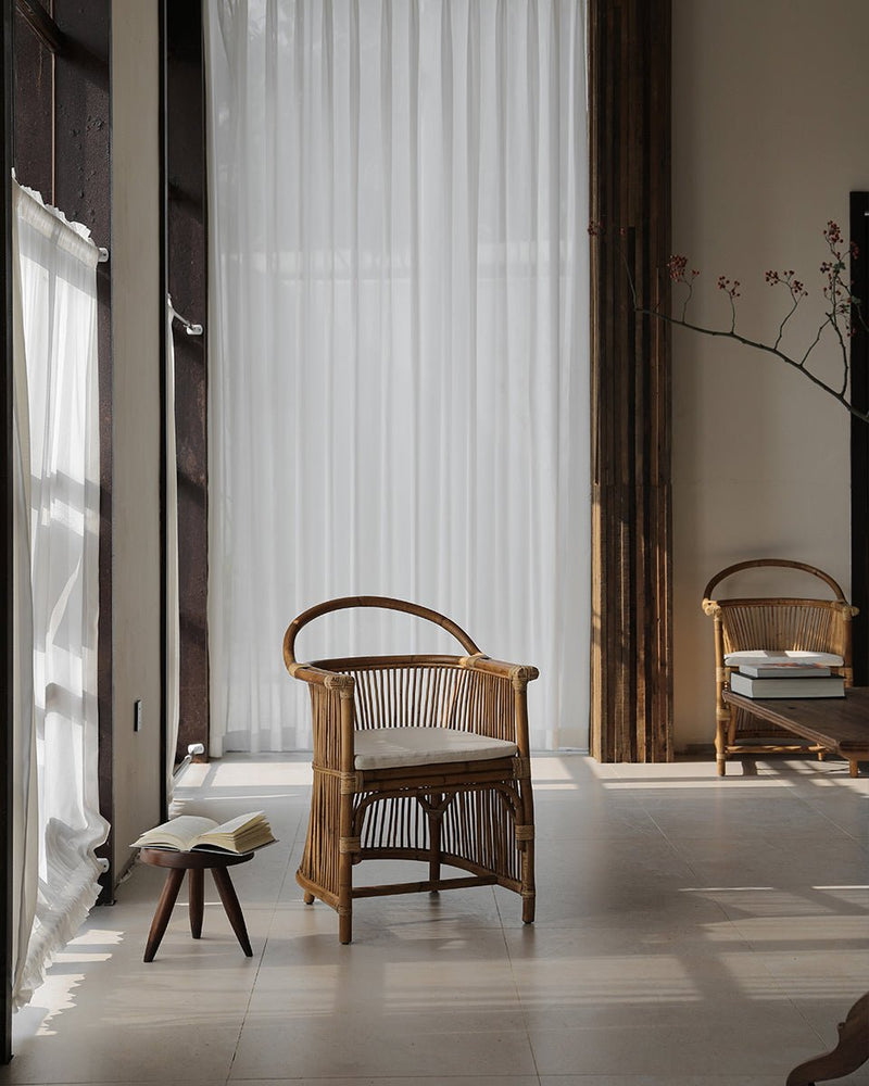 Cape Chair featuring natural rattan design in a sunlit, minimalistic room