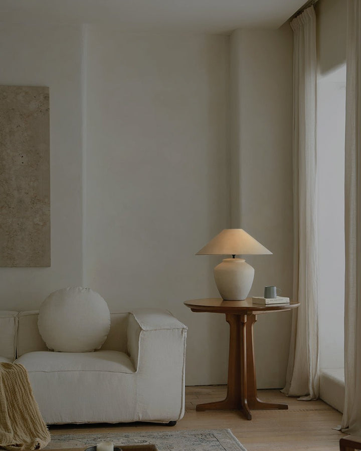 Minimalist living room with white lamp and beige decor on wooden side table