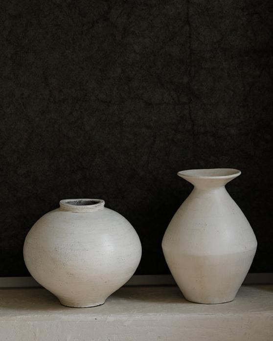 Set of two ceramic vases. A rounded white vase and a tall, off-white vase with a narrow neck and flared rim. 
