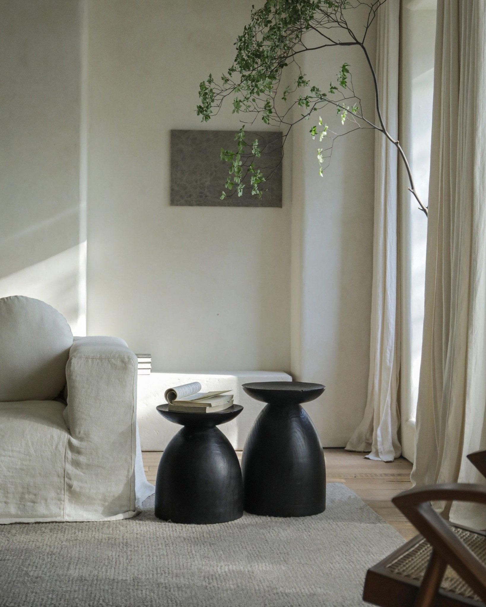 Black Sandglass tables in interior setting with Samanea saman wood, minimalist design
