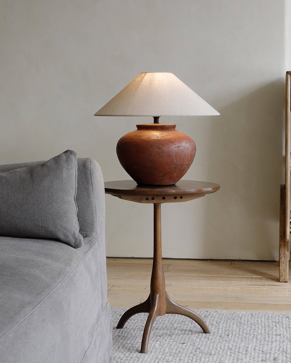 Twig side table with lamp, tripod base, and terracotta base lamp for a modern living room