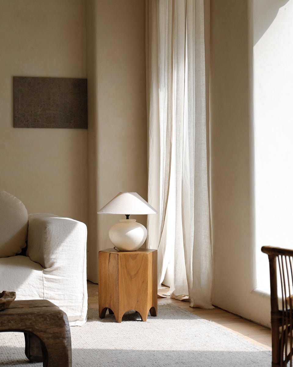 Hexagon side table in natural wood with a lamp, perfect as a versatile accent piece in a modern living room.