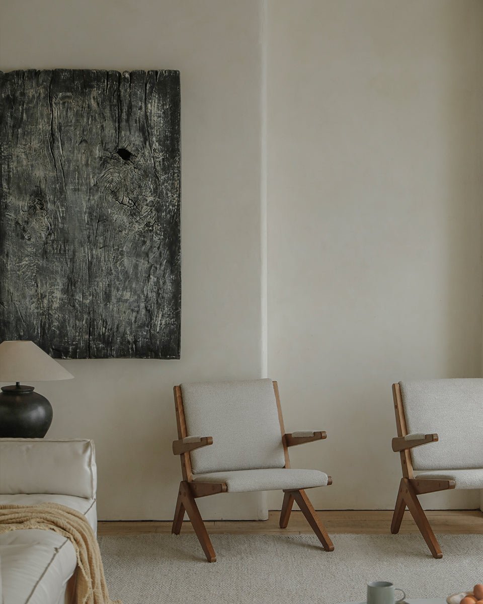 Scissors Chair in a modern interior setting. Red oak frame with light grey cushions and unique scissor legs.