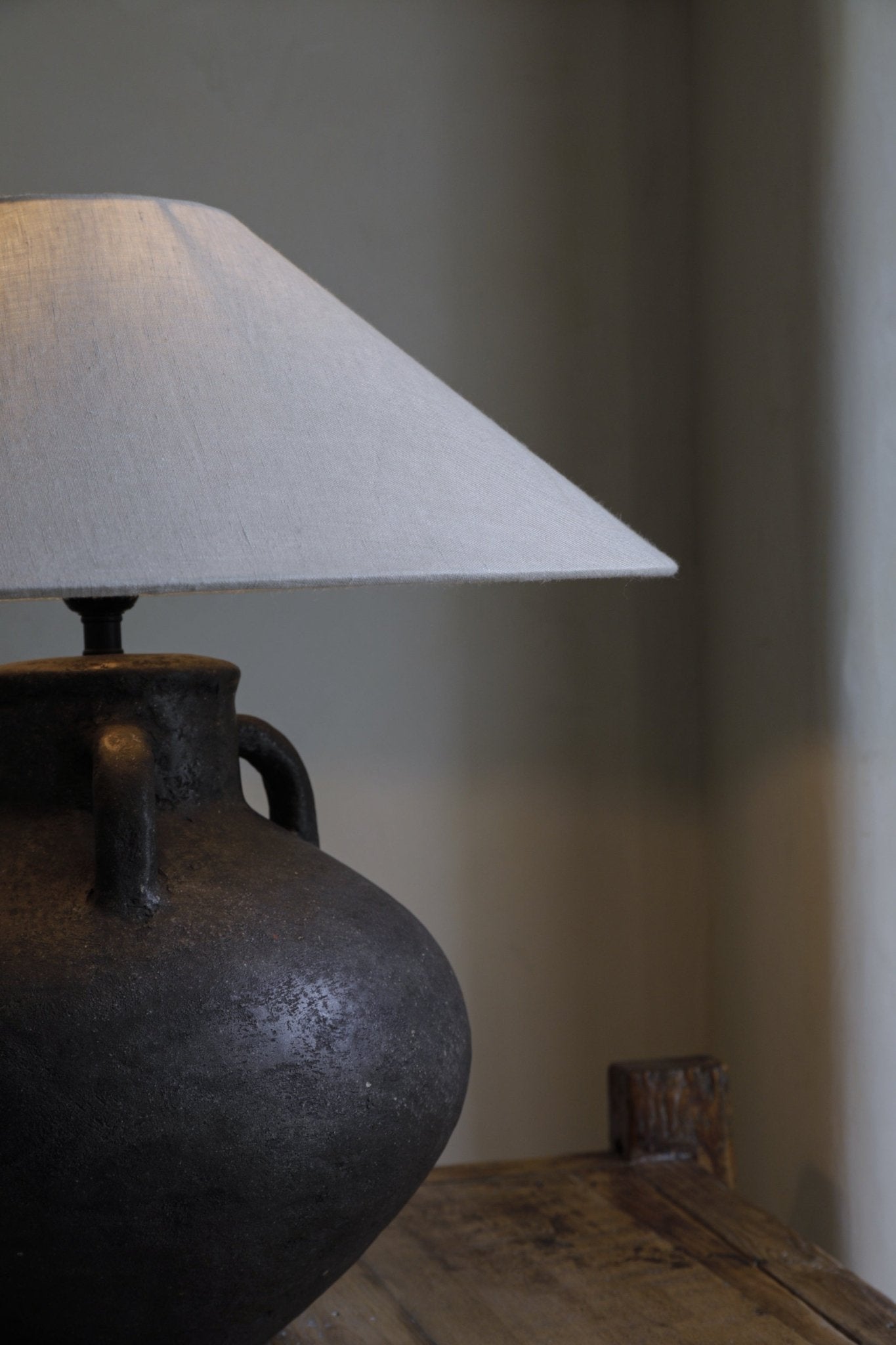 Ear Lamp with a textured dark clay base and off-white shade, providing soft lighting for home decor.