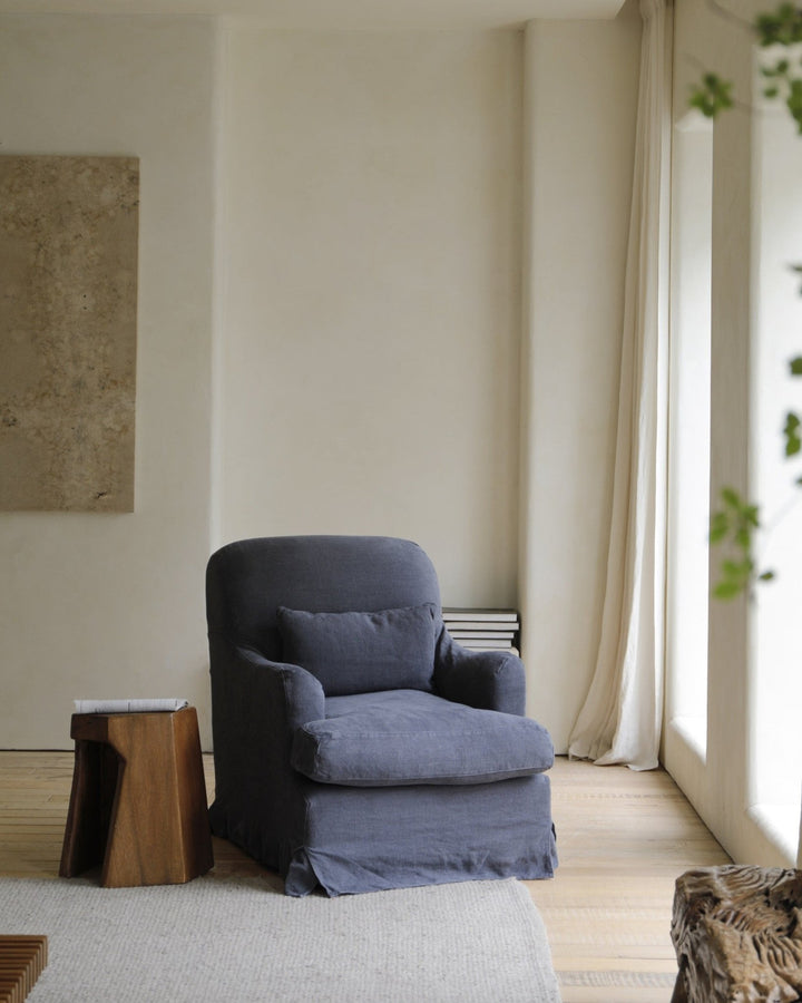 Linen gray slipcover armchair with cushion in a bright, modern living room
