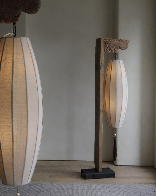 Chinese floor lamp with a natural wood base and two fabric lampshades.