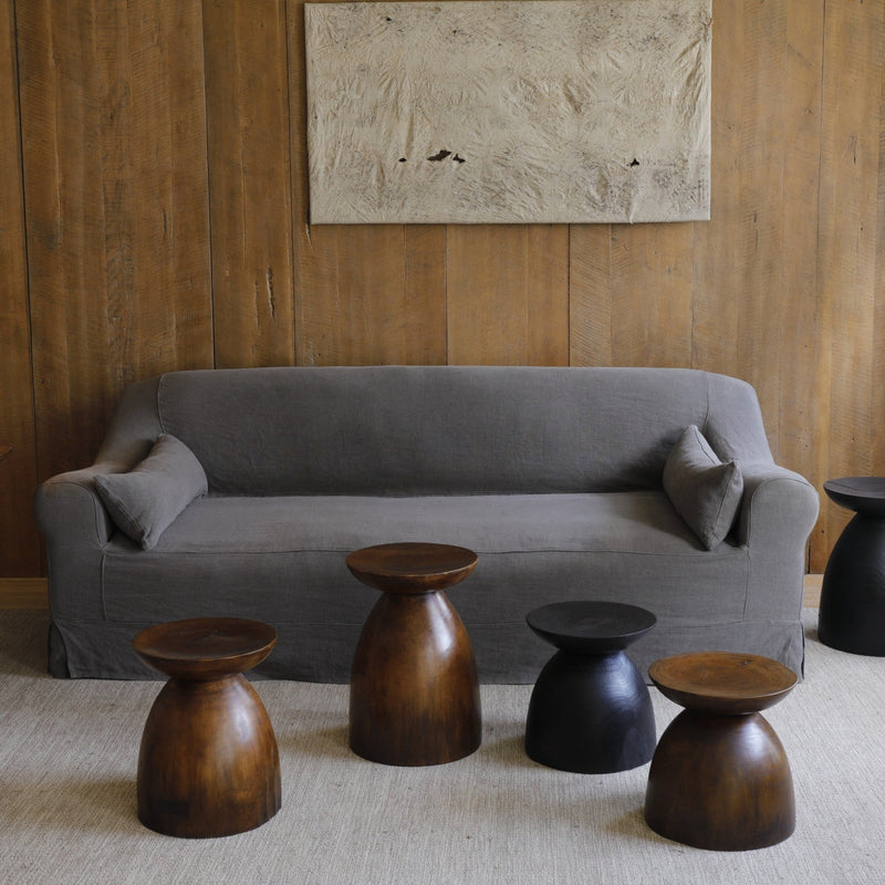 Sandglass tables beside a gray sofa in a cozy minimalist living room.