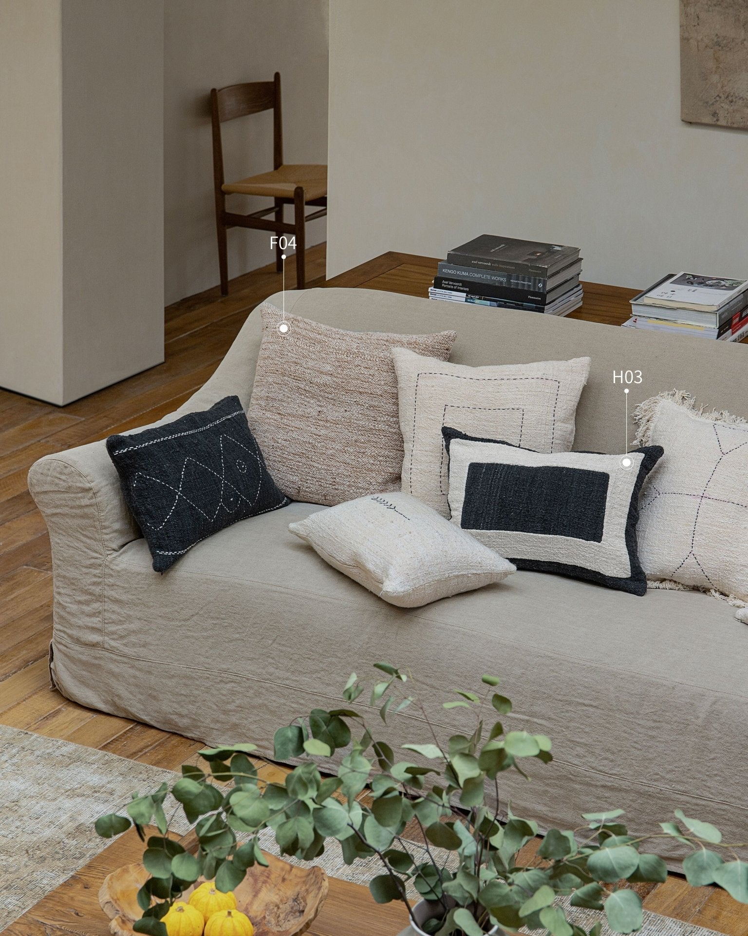 Cotton pillows with stitched designs in neutral colors on a beige sofa